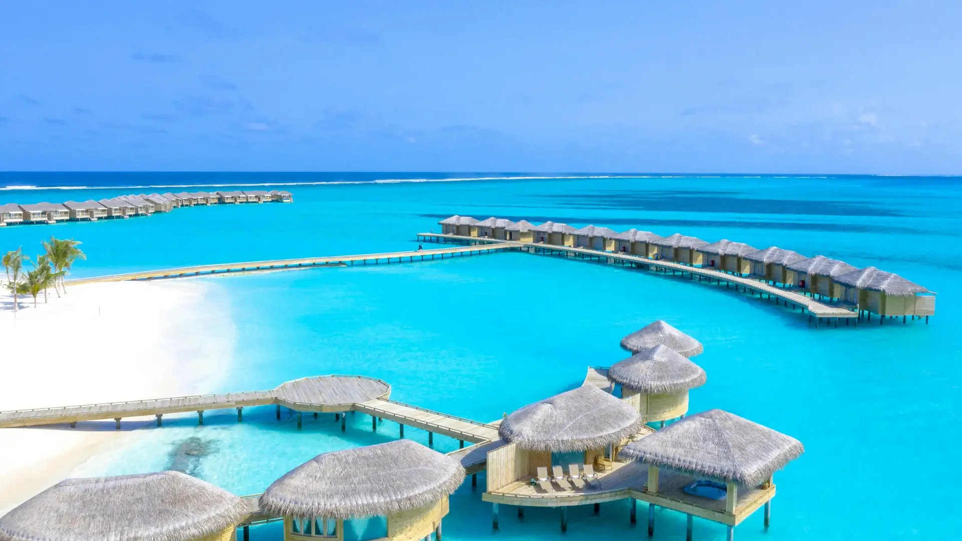 Aerial view of overwater bungalows on a turquoise Maldives lagoon